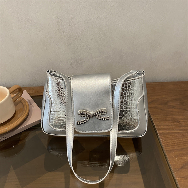 Elegante Handtasche mit Krokodilmuster und Schleifendetail