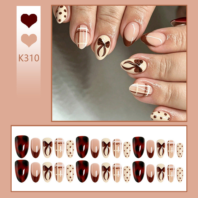 Kunstnagelset mit eleganten Schleifen- und Karamell-Motiven Karnz