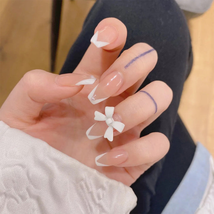 Elegante Kunstnägel mit durchscheinendem French-Tip und dekorativen Blütenakzenten Karnz