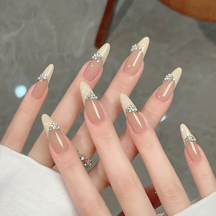 Kunstnagelset mit eleganten Spitzen und funkelnden Applikationen Karnz