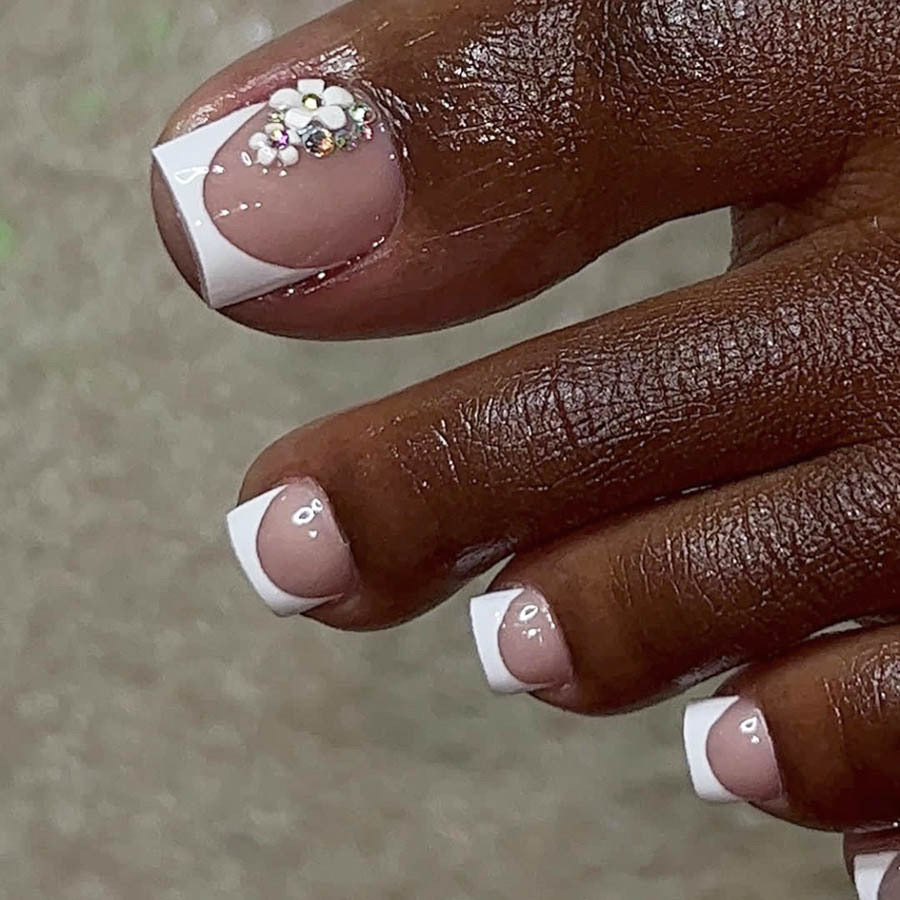 Kunstnagelset mit elegantem französischen Spitzen-Design und glitzernden Akzenten Karnz