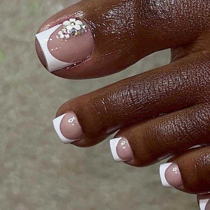 Kunstnagelset mit elegantem französischen Spitzen-Design und glitzernden Akzenten Karnz