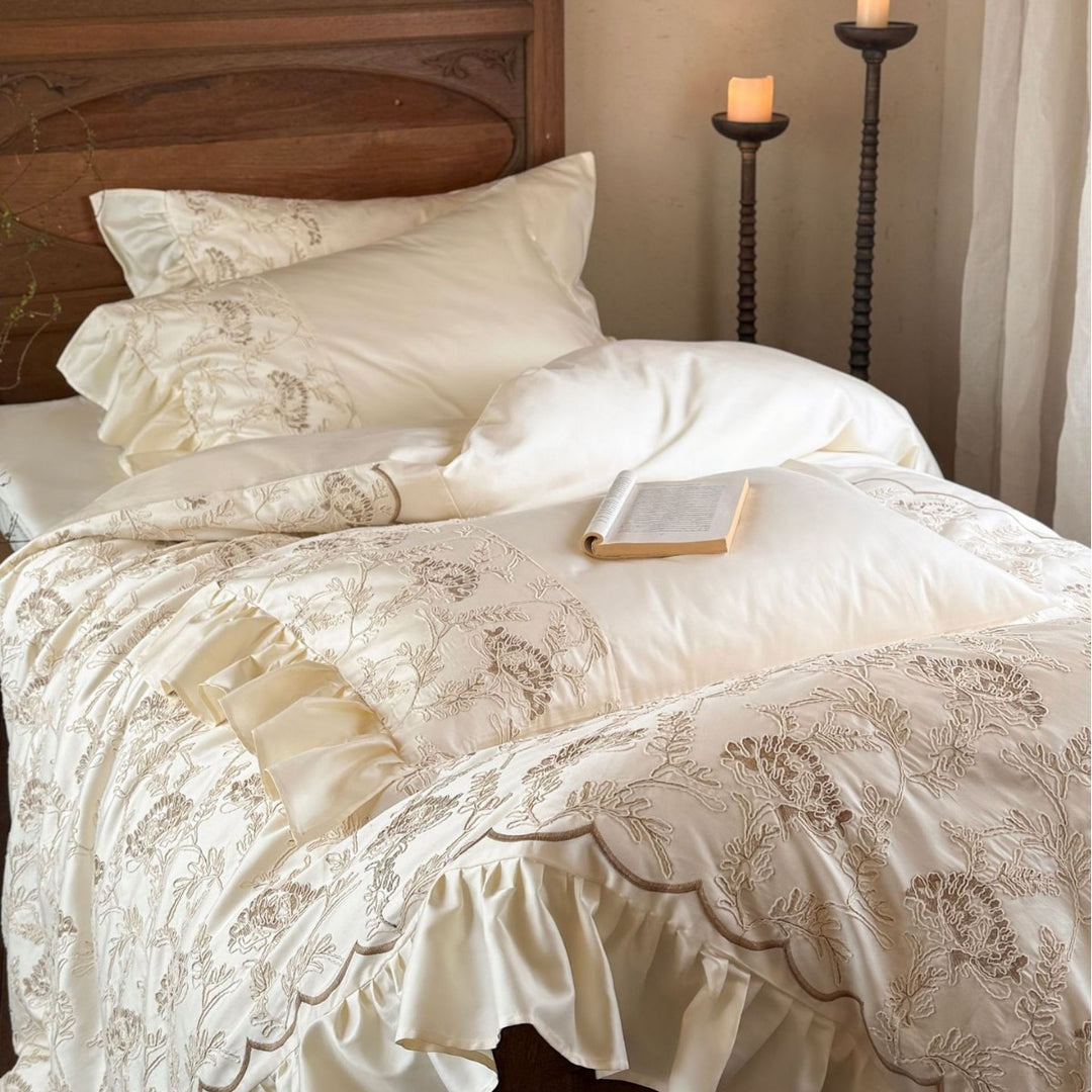 Steppbett mit floraler Stickerei, Satinvolant und dekorativer Biese