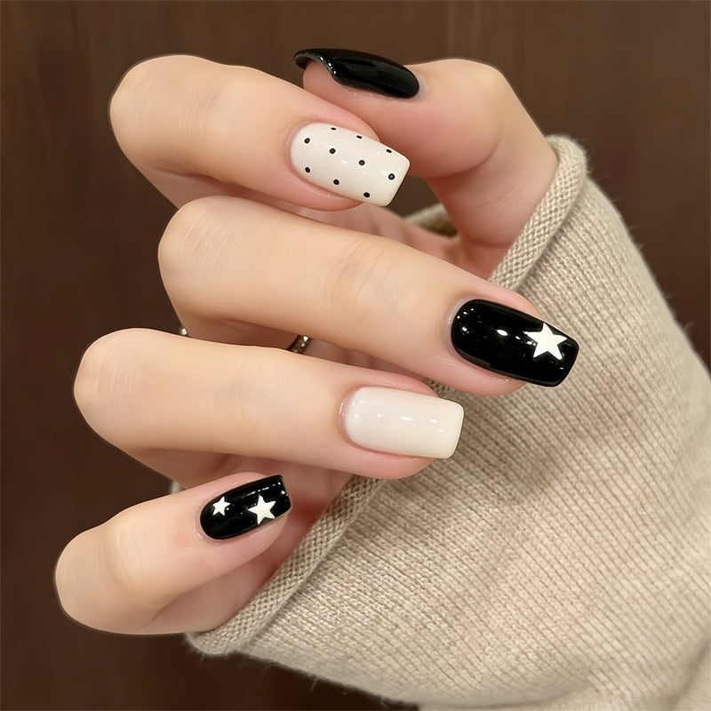 Künstlerisches Press-On-Nageldesign mit Sternen und Punkten Karnz