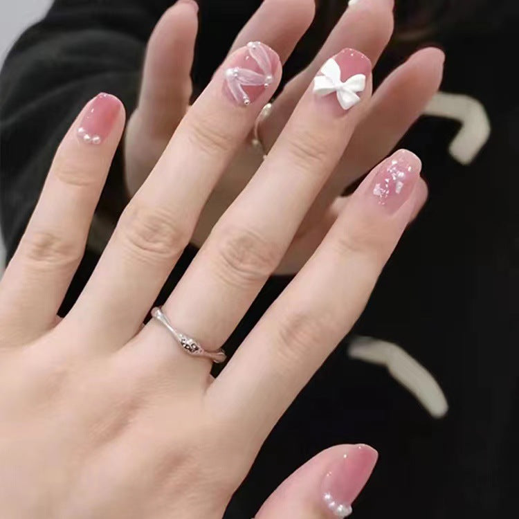Glamouröse Nagelkunst mit Perlen- und Schleifenakzenten Karnz