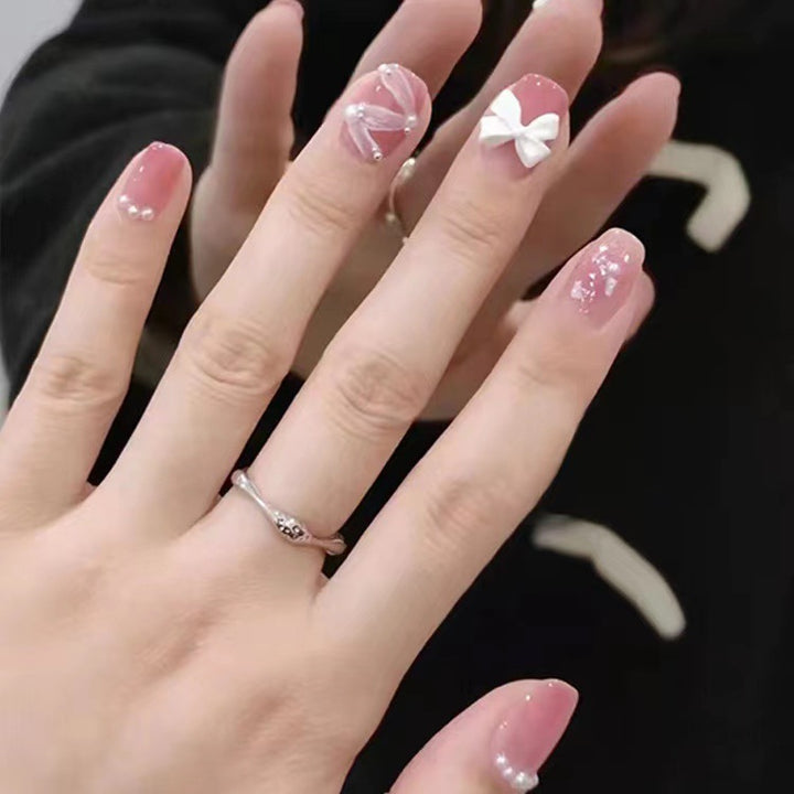 Glamouröse Nagelkunst mit Perlen- und Schleifenakzenten Karnz