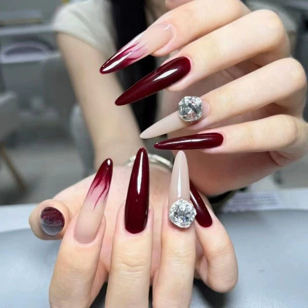 Elegante Stiletto Nagelverbesserungen mit Edelsteinakzenten Karnz