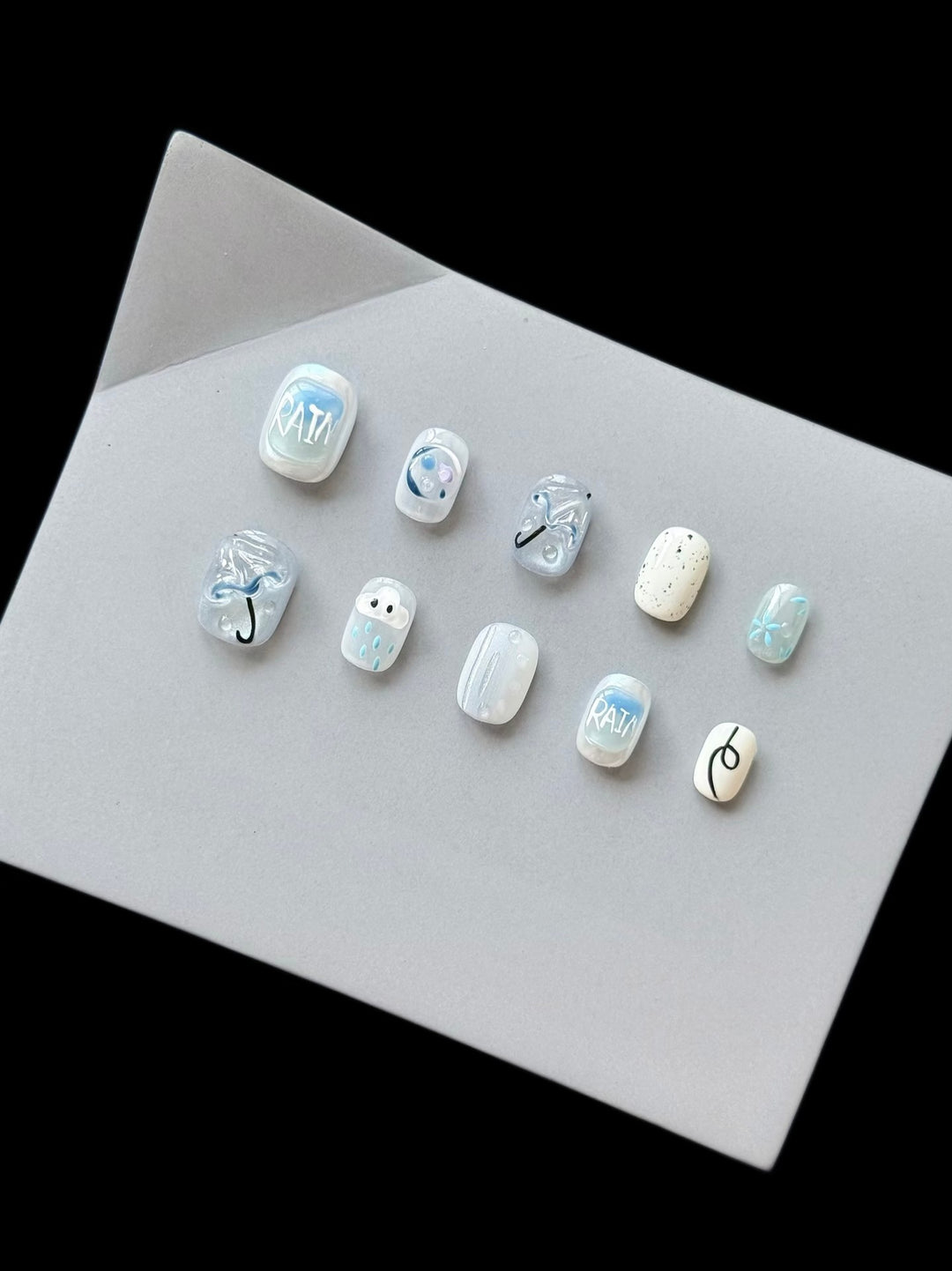 Künstlerisches Press-On Nagelset mit Regen-Thema