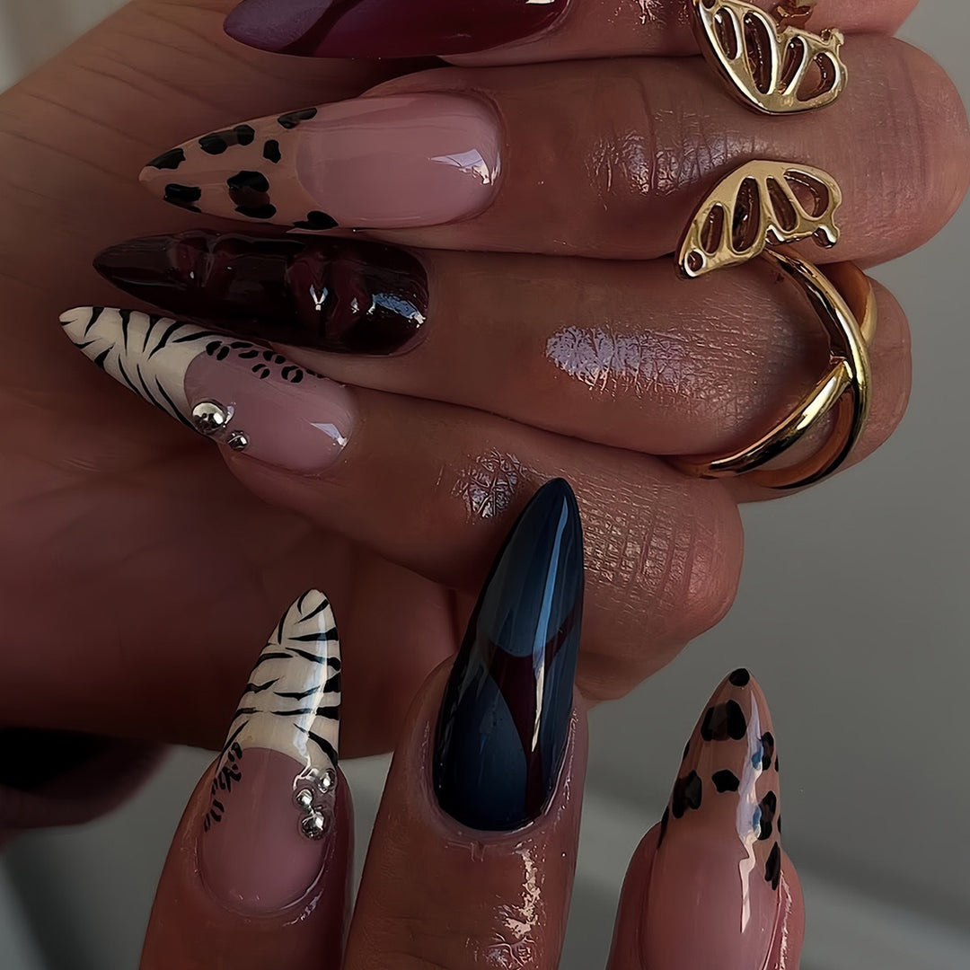 Künstlerische Stiletto-Nagelverlängerungen mit trendigem Tierdruck und Schmuckakzenten Karnz
