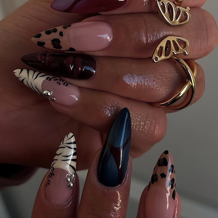 Künstlerische Stiletto-Nagelverlängerungen mit trendigem Tierdruck und Schmuckakzenten Karnz