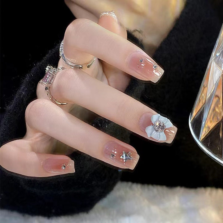 Kunstvolle Nagelspitzen mit floralen und glitzernden Akzenten Karnz