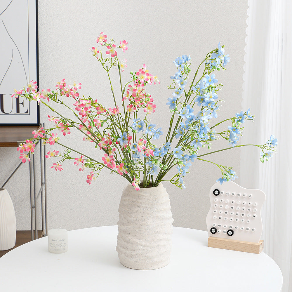 Künstlicher Blütenzweig mit zarten blauen Blumen und grünen Beeren Karnz