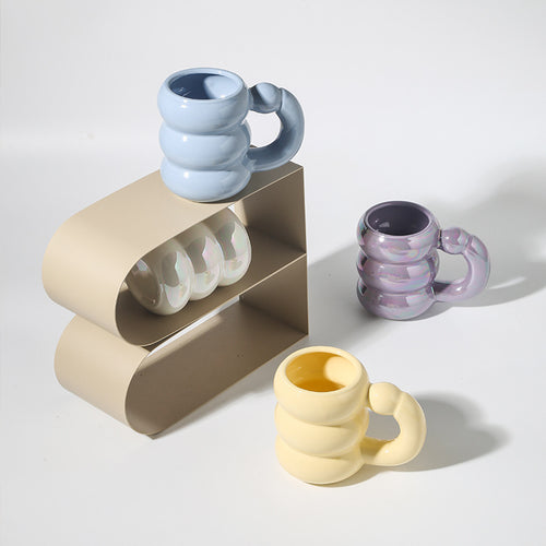 Skulpturaler Keramikbecher mit irisierender Glasur und gewölbtem Ringhenkel