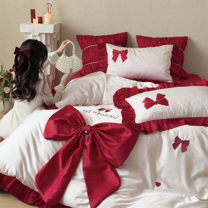 Romantische Bettwäsche-Garnitur mit XXL-Satin‑Schleife, Volant und bestickten Applikationen