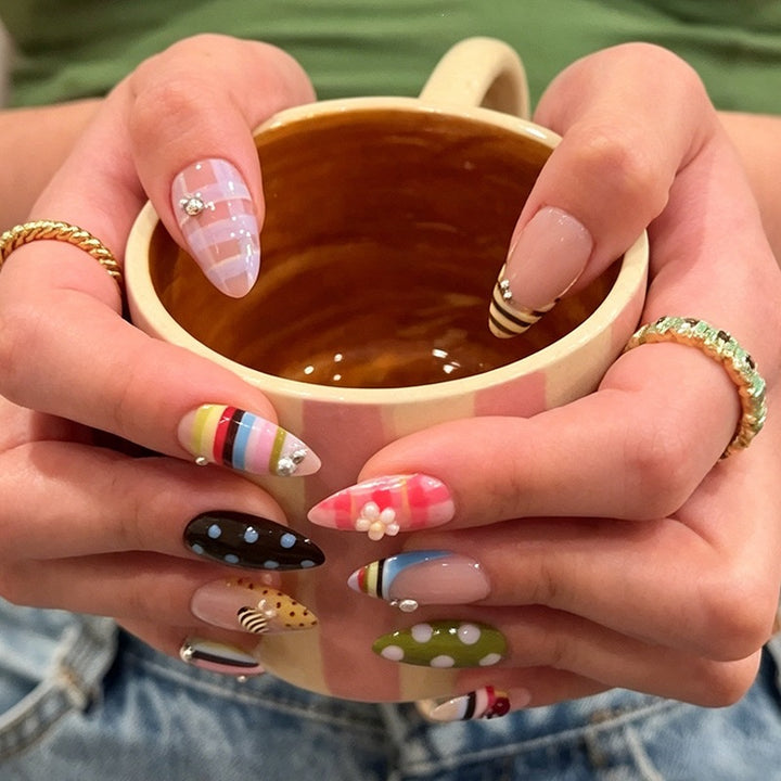 Kunstnagelset mit bunten Mustern und Glitzerdetails Karnz