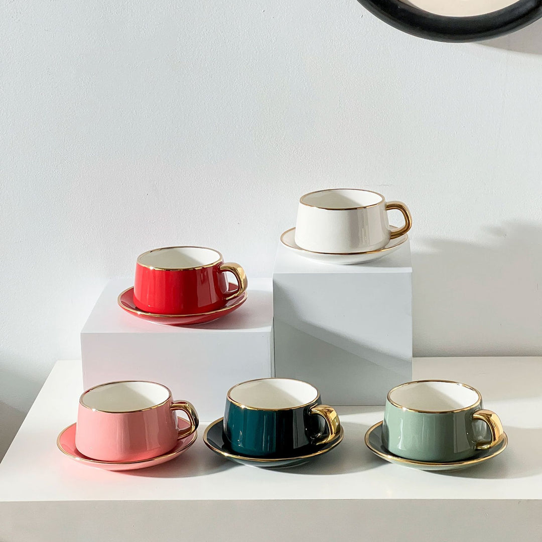 Elegante Porzellan-Tasse mit Untertasse und skulpturellem Goldhenkel