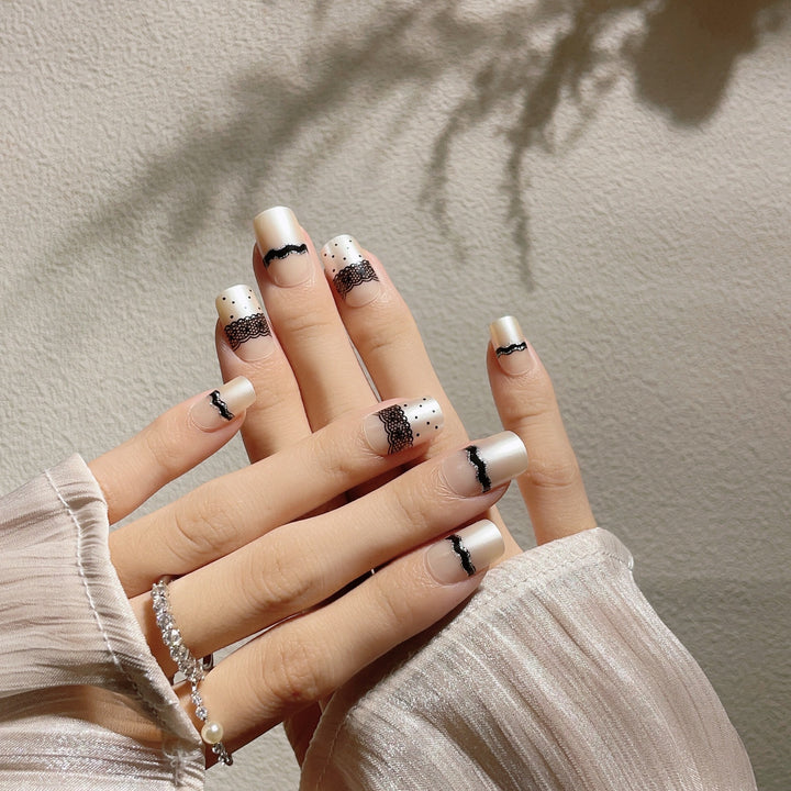 Künstlerisches Press-On-Nageldesign mit Spitze und Punkten