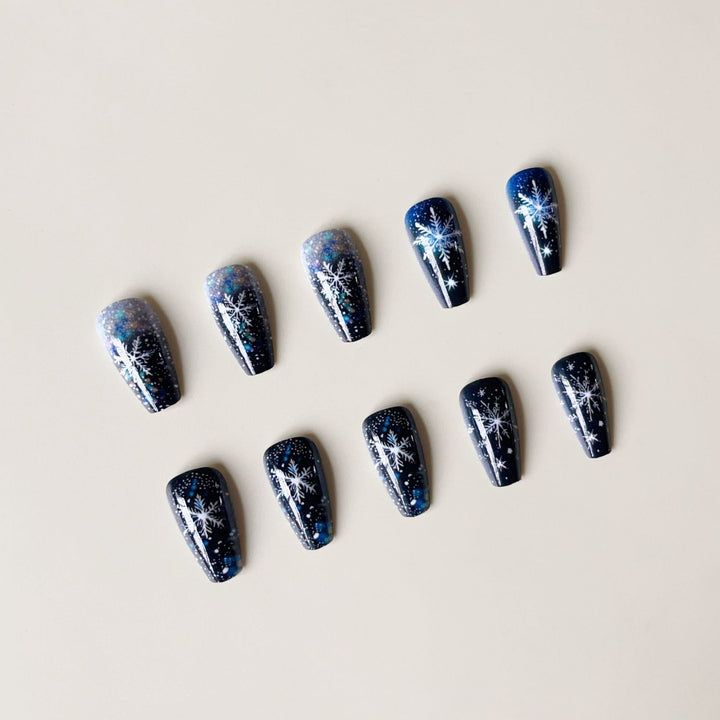 Kunstnagelset mit funkelnden Schneeflocken und Glitzerakzenten Karnz