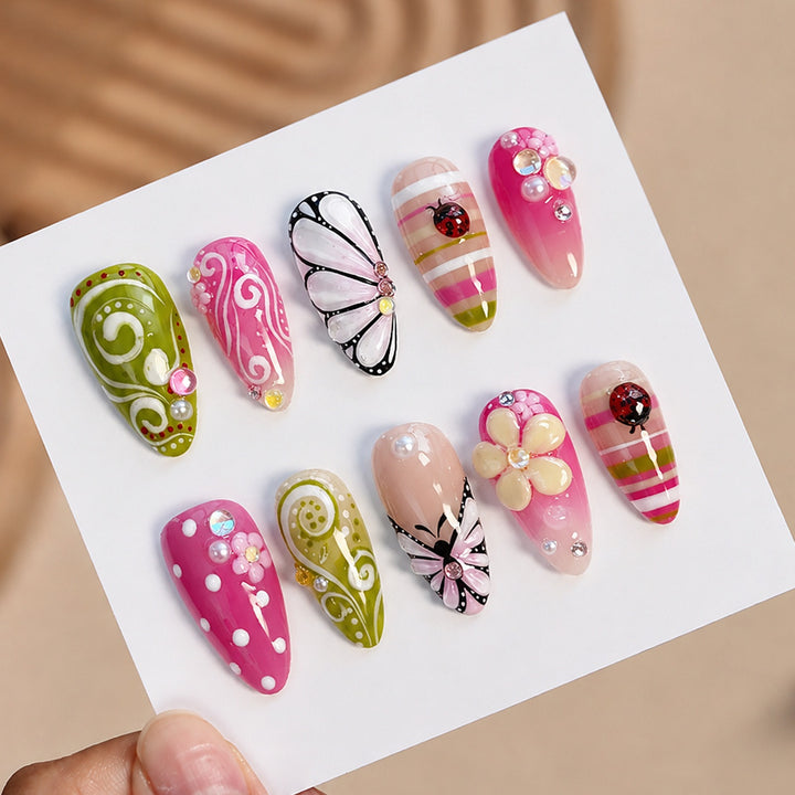 Kunstnagelset mit verspielten Blumen- und Glitzermotiven Karnz