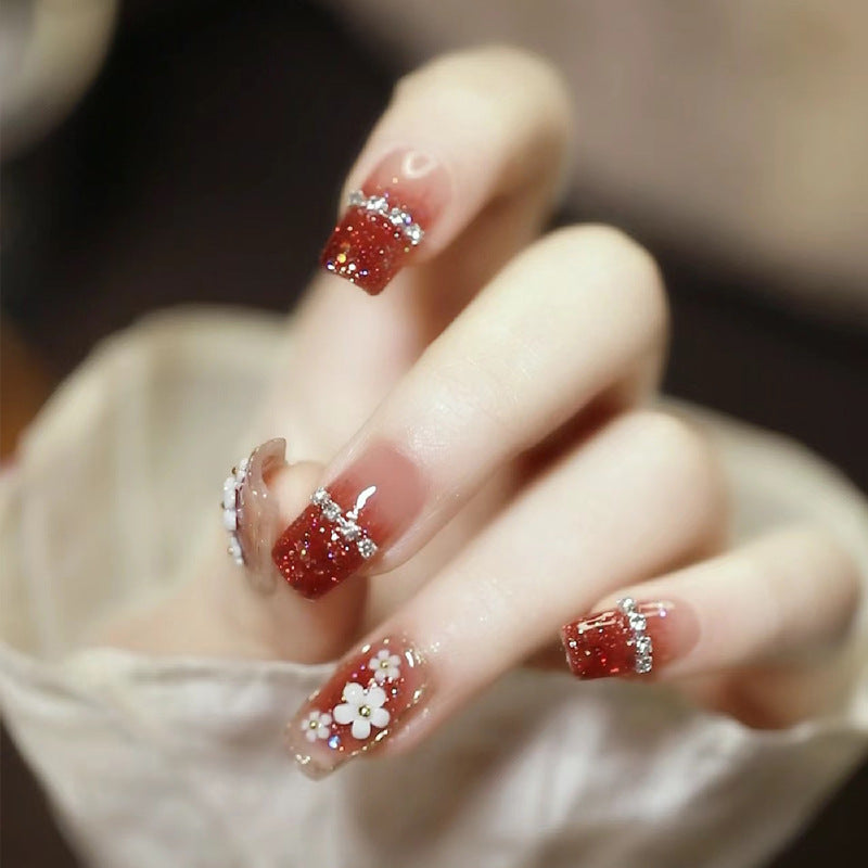 Künstlerische Press-On Nagelkunst mit floralen und Glitzerakzenten Karnz