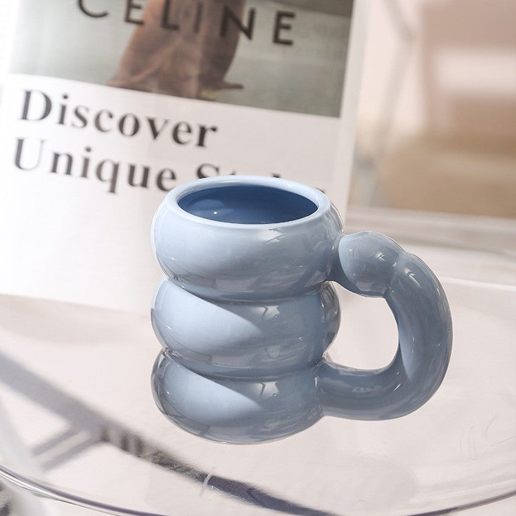 Skulpturaler Keramikbecher mit irisierender Glasur und gewölbtem Ringhenkel