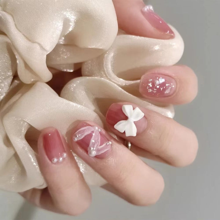 Glamouröse Nagelkunst mit Perlen- und Schleifenakzenten Karnz