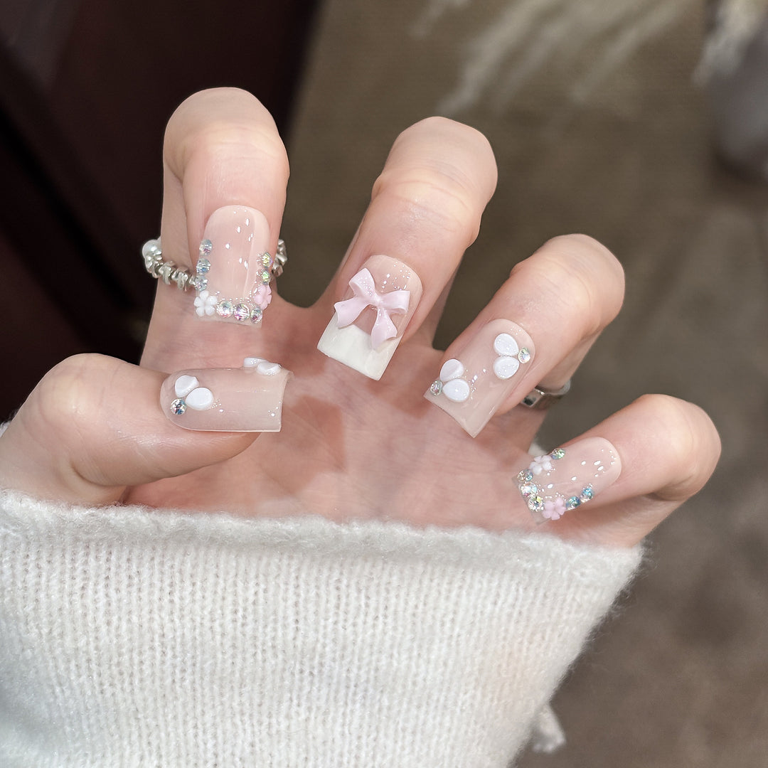 Dekoratives Nagelkunstset mit floralen Details und Schleifenakzenten