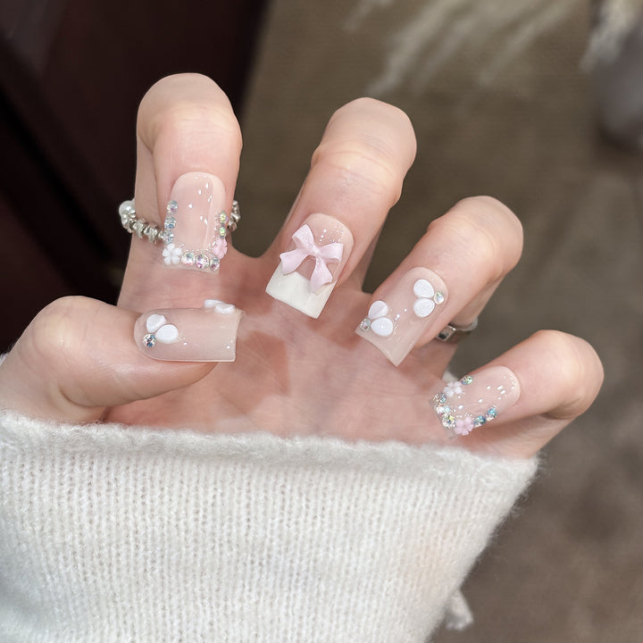 Dekoratives Nagelkunstset mit floralen Details und Schleifenakzenten