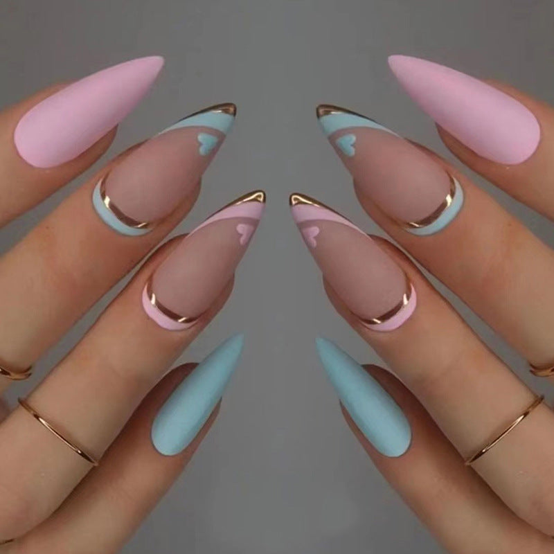 Kunstvolle Stiletto-Nägel mit Goldakzenten und Herz-Design Karnz