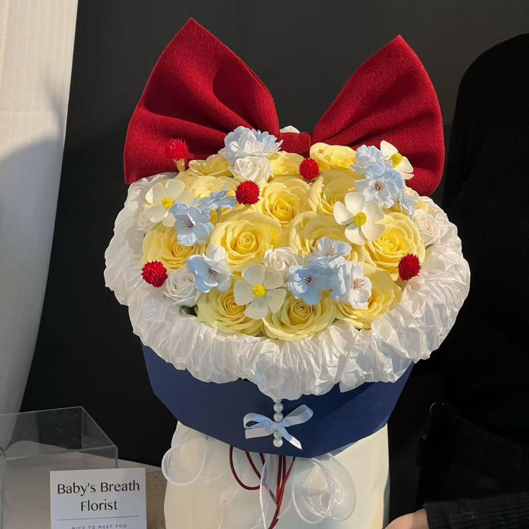 Künstliches Blumenarrangement mit Schleifenakzent