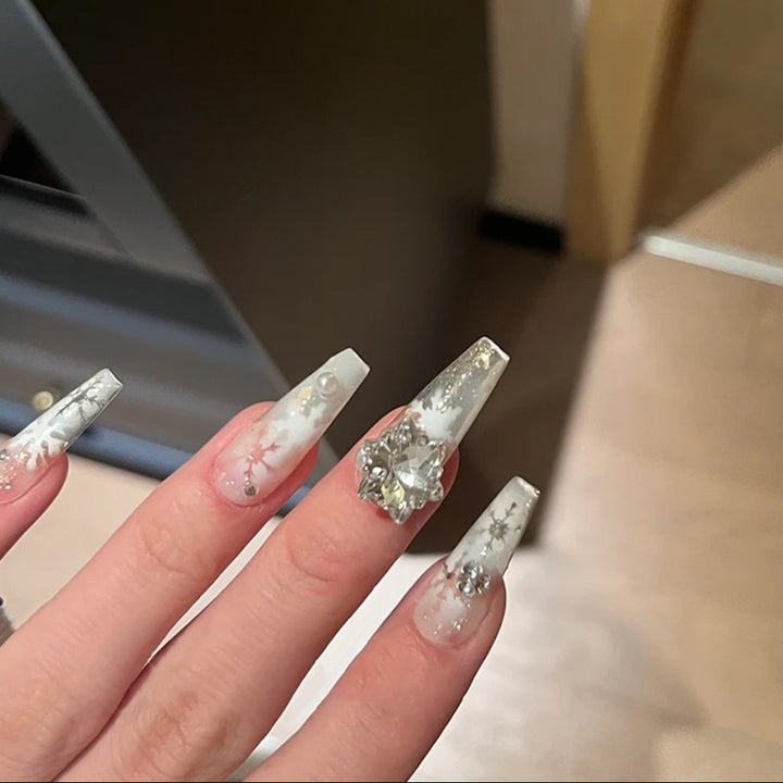 Kunstnagelset mit frostigem Schneeflocken-Design und funkelnden 3D-Applikationen Karnz