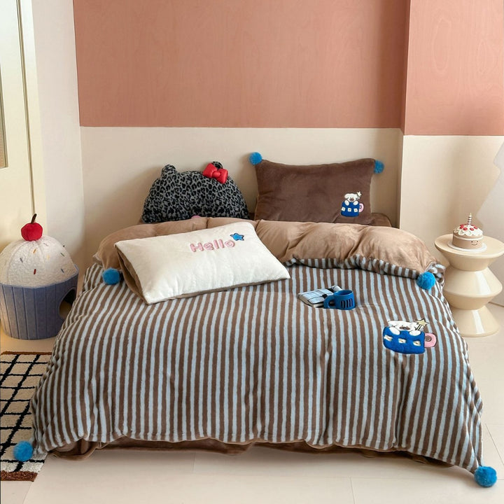 Kuschelige gestreifte Wohndecke mit Pompons und Plüschapplikationen