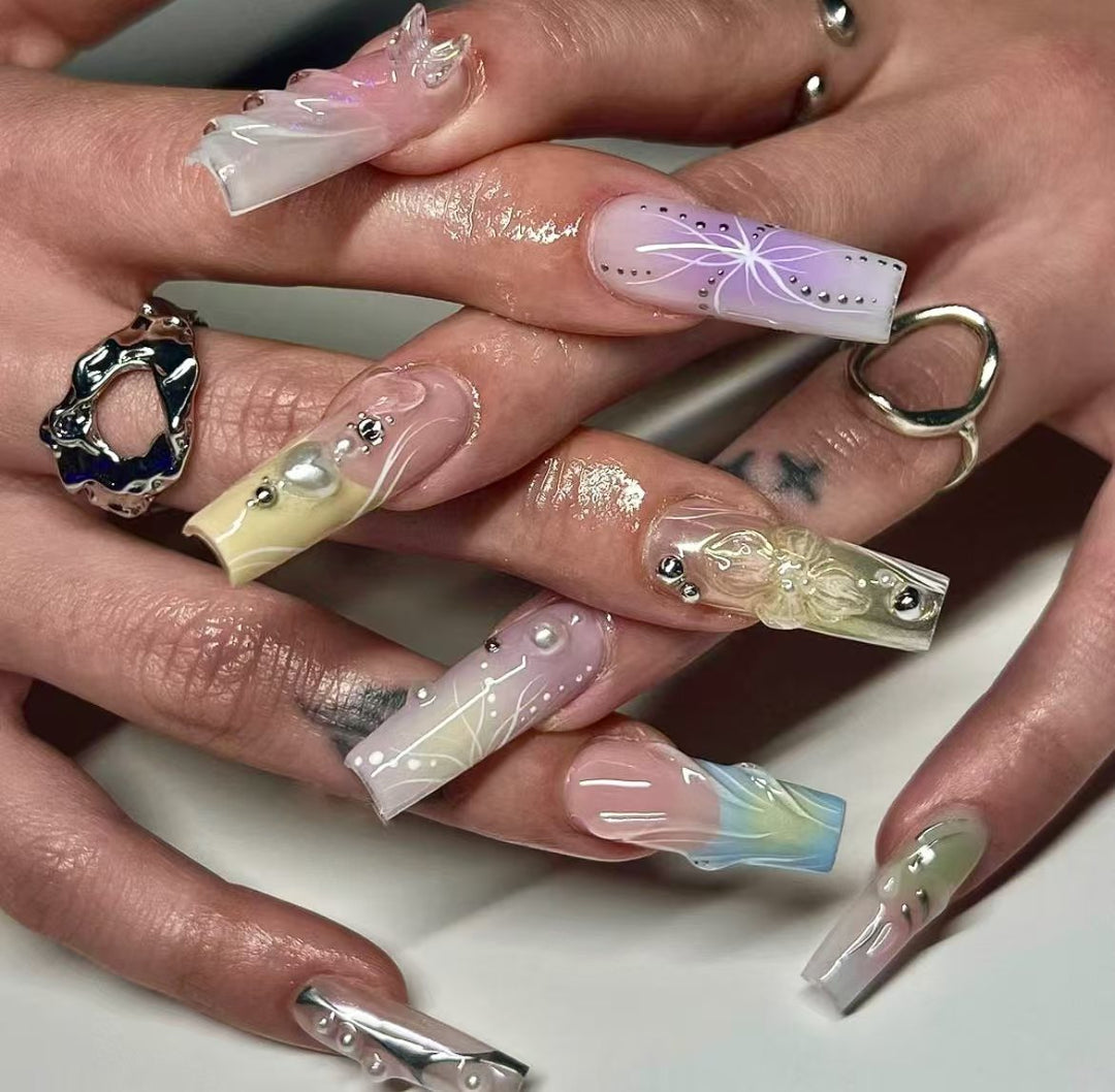 Kunstnagelset mit eleganten floralen und glitzernden Akzenten Karnz