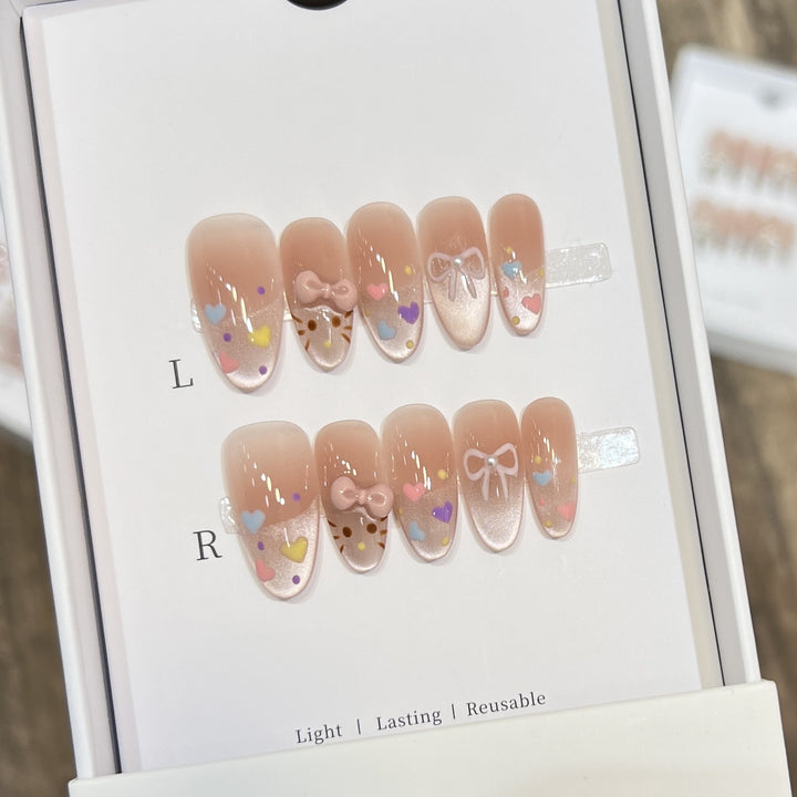 Dekorativer Press-On Nail Set mit bunten Herz- und Schleifendekoren Karnz