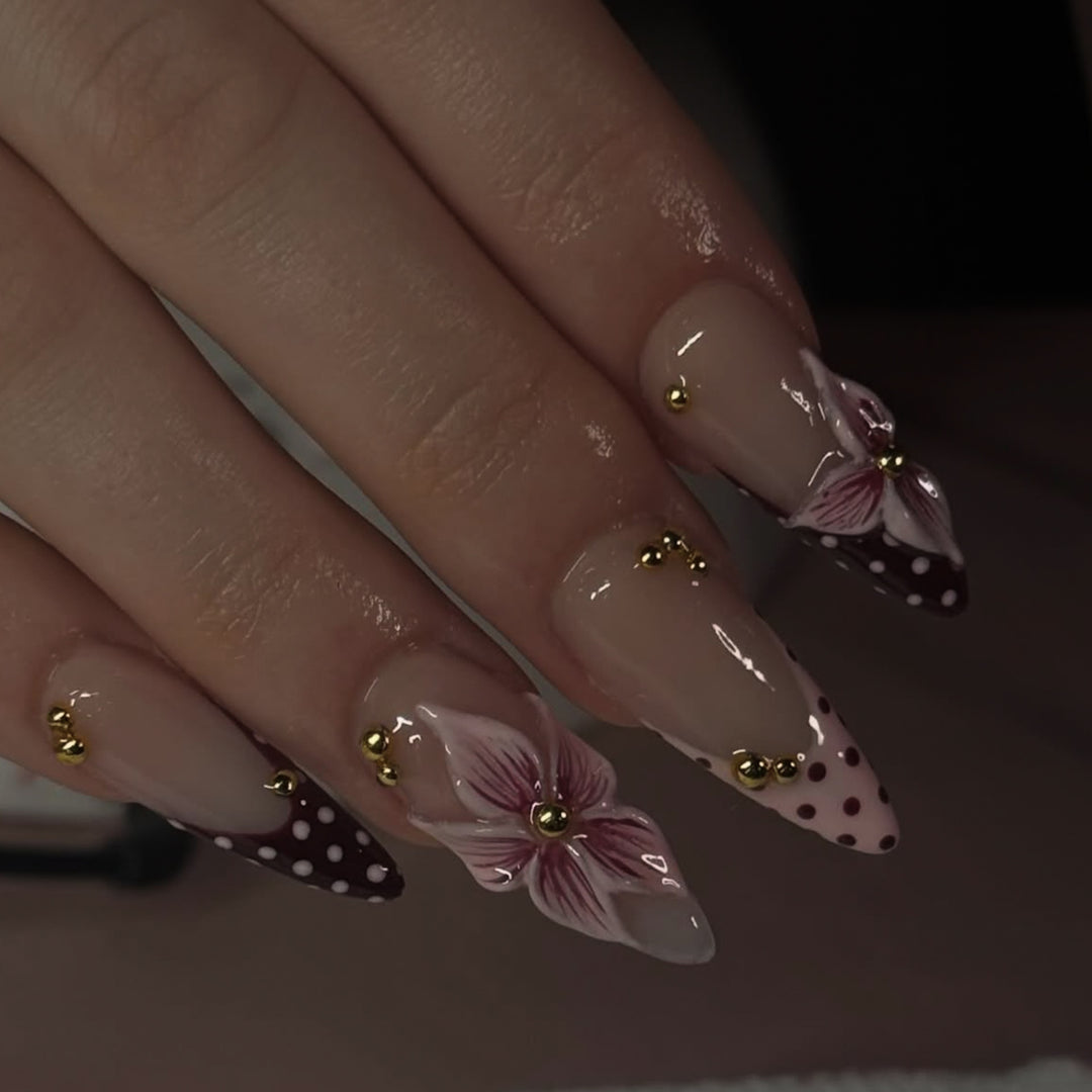 Kunstvolle Stiletto-Nägel mit floralen Akzenten und Glitzer Karnz