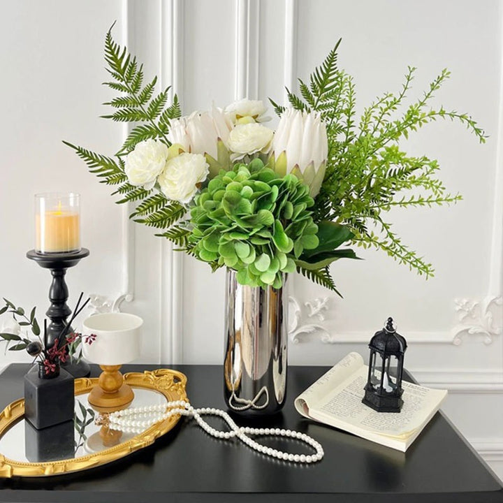 Spiegelnde hohe zylindrische dekorative Metallvase mit künstlicher Hortensie und Protea Arrangement