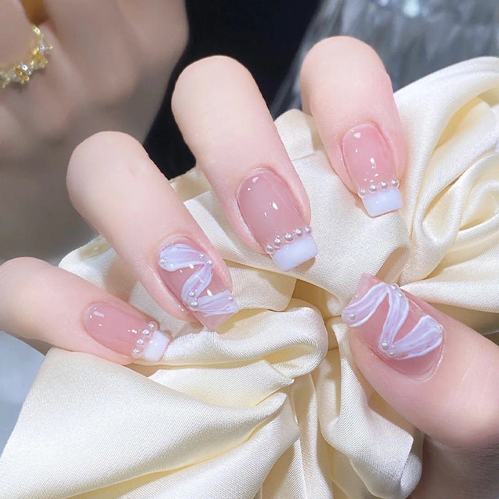 Elegantes Kunstnagelset mit stilvollem Wellenmuster und Perlenakzenten Karnz