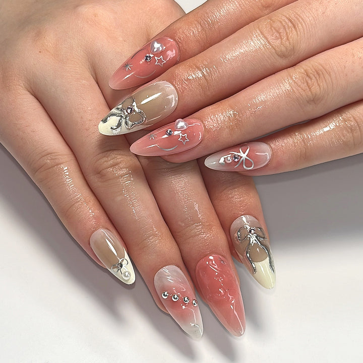 Kunstvolle Nagelspitzen mit Glitzer- und Schleifenmotiven Karnz