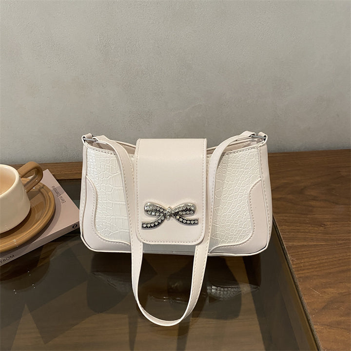 Elegante Handtasche mit Krokodilmuster und Schleifendetail