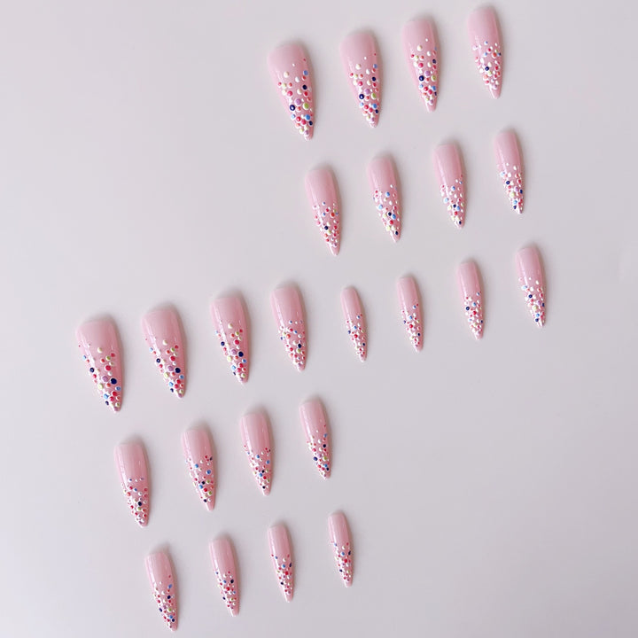 Kunstnagelset mit bunten Glitzerpunkten und eleganten Spitzen Karnz