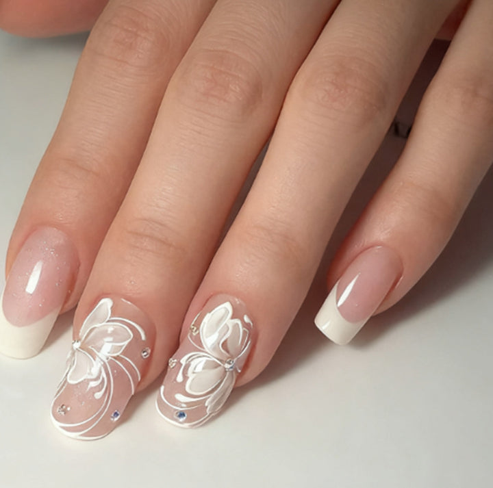 Kunstnägel mit floralen Verzierungen und Glitzerdetails Karnz