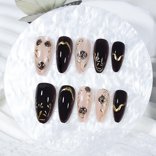 Kunstnagelset mit eleganten Goldverzierungen und originellen Mustern Karnz