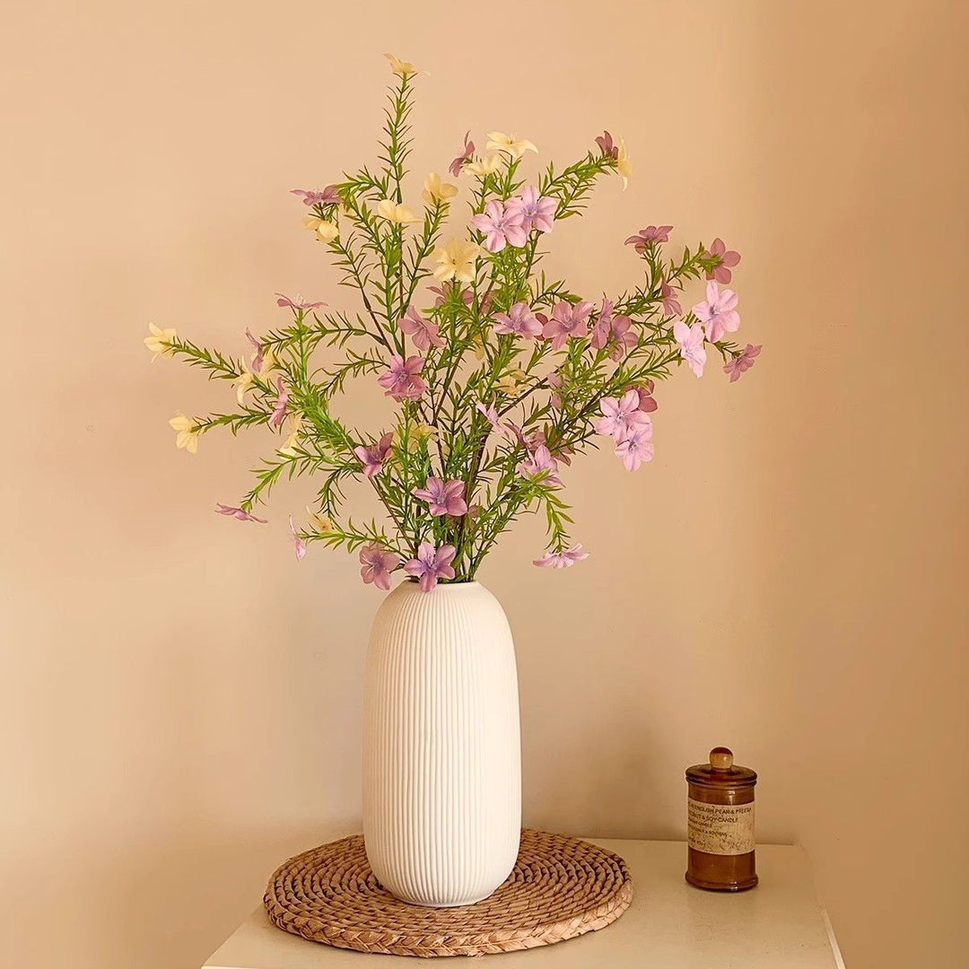 Lebensechte Blumenarrangement mit eleganter Vase