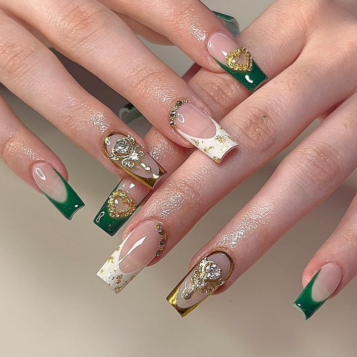 Exquisite Kunstnägel mit Goldverzierungen und Glitzerakzenten Karnz
