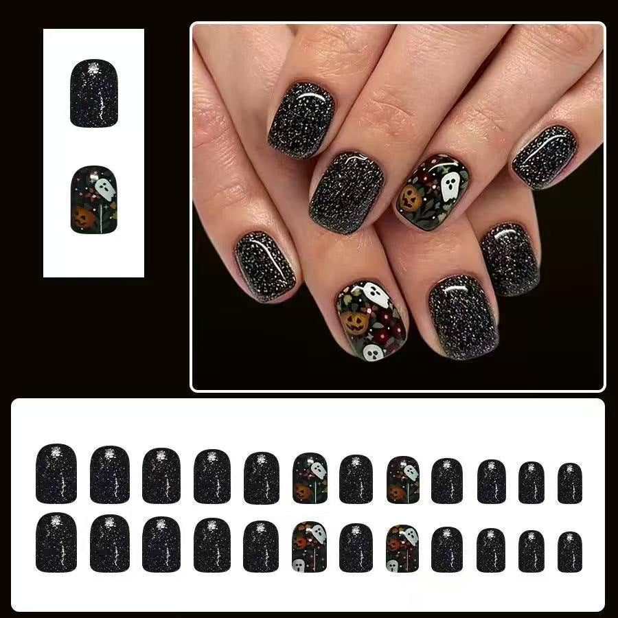 Kunstnagelset mit Halloween-Motiven und Glitzerakzenten Karnz