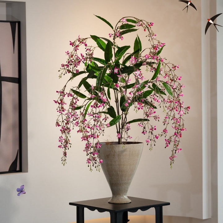 Lebensechte künstliche Blumenarrangement in dekorativem Topf