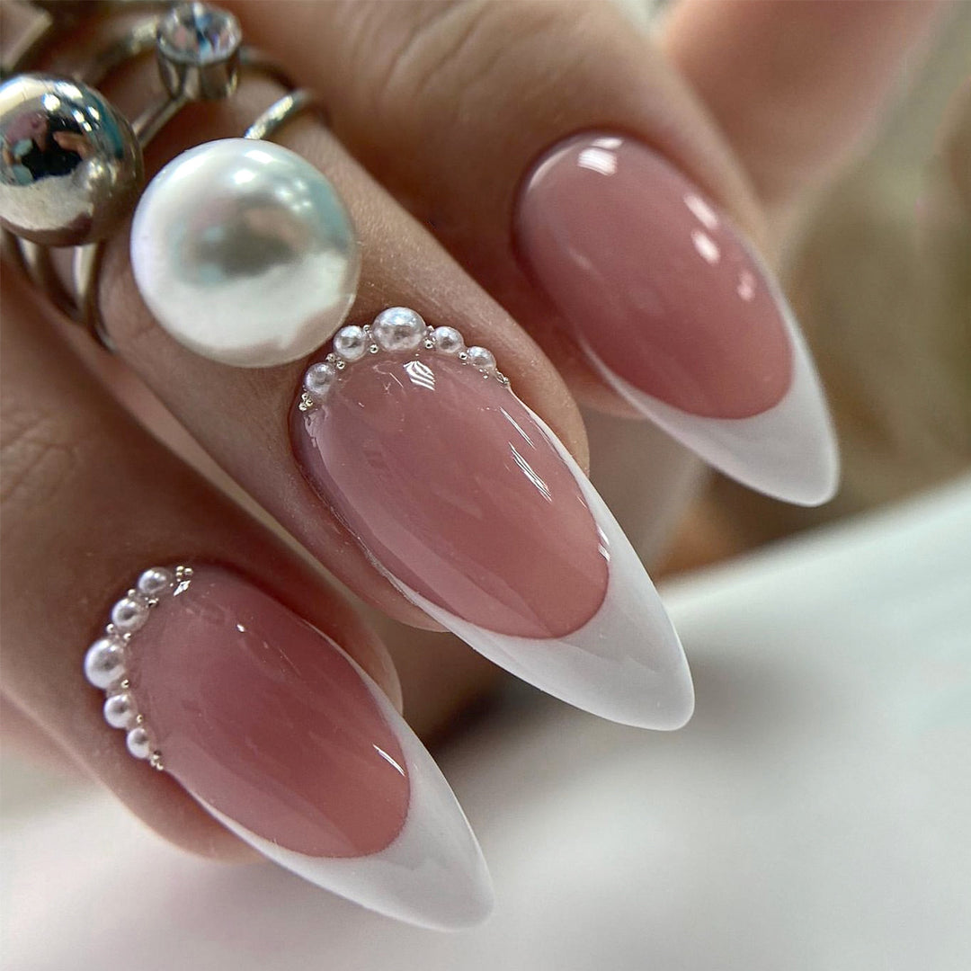Kunstnagelset mit eleganter French Spitze und perlenverzierten Akzenten Karnz