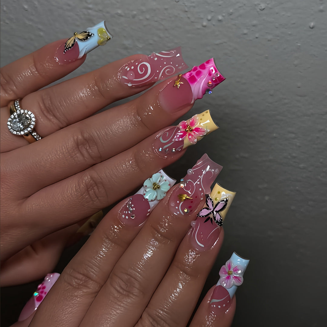 Kunstvolle Fingernägel mit Floralen Akzenten und Glitzer Karnz