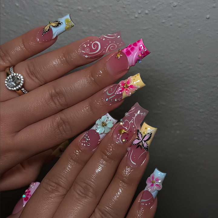 Kunstvolle Fingernägel mit Floralen Akzenten und Glitzer Karnz