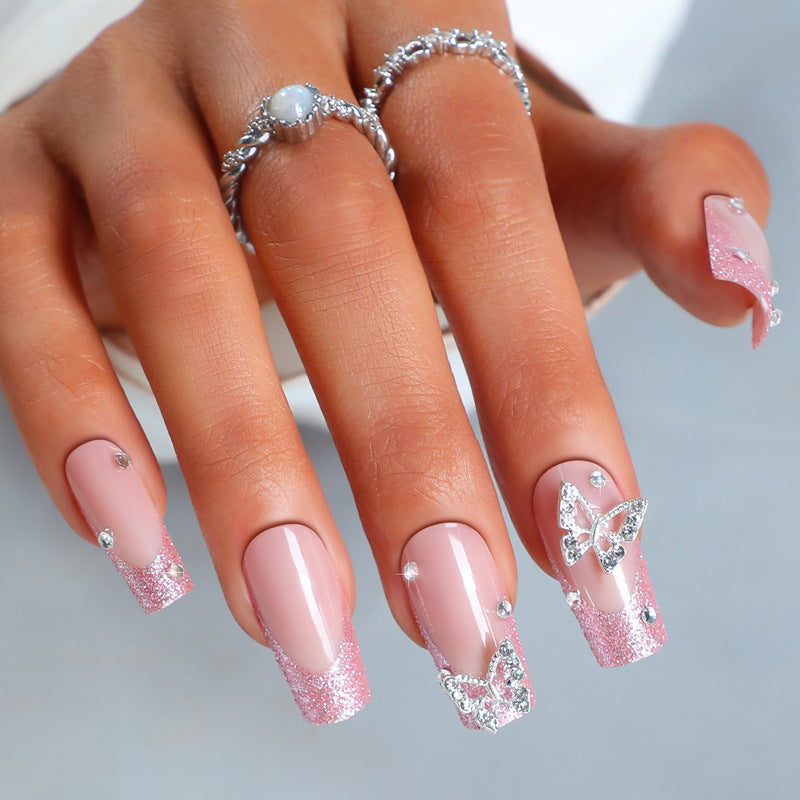 Kunstnagelset mit funkelnden Glitzerakzenten und eleganten Schmetterlingsmotiven Karnz